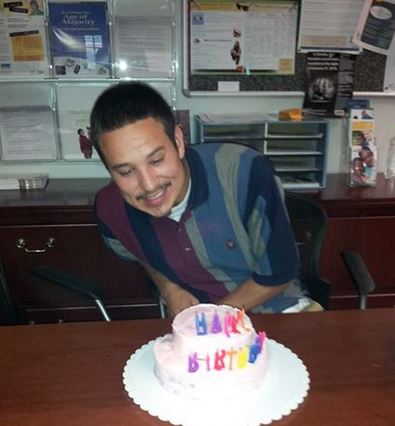 A young man getting a special birthday cake delivery at the Project Everlast Omaha office.