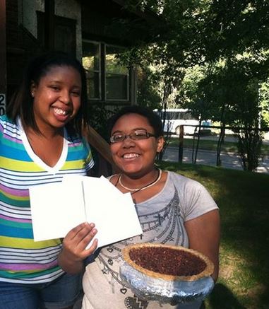 Schalisha giving a homemade pecan pie, baked by a volunteer, to a young woman on her birthday.
