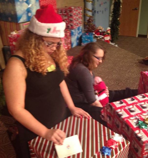 Ty from the Omaha council opening her gift near the massive stack of packages.