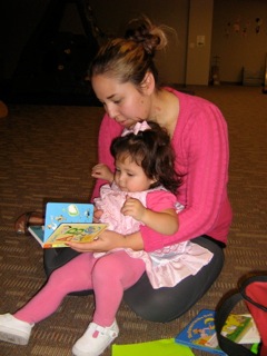 One of the young mothers Nancy works with reading to her toddler.