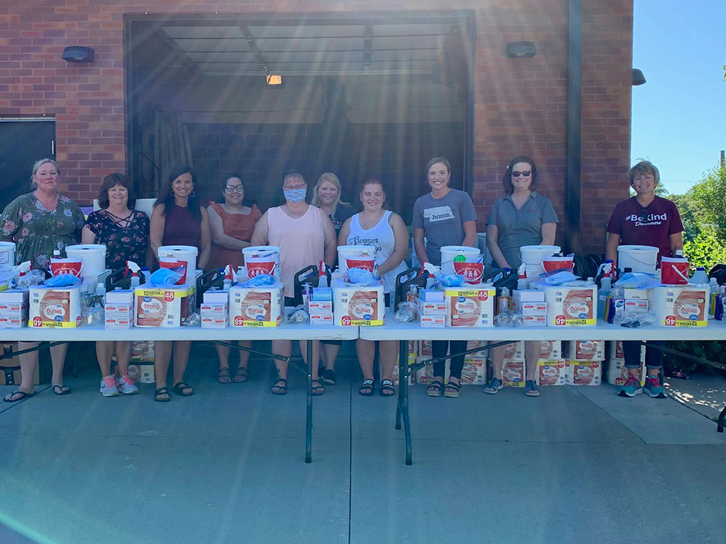 Columbus' Communities for Kids, the Community and Family Partnership, Columbus Public Schools, and other partners stand at attention, ready to hand out essential items. 