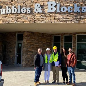 Here is Cory Quimby (r) with his business partner and wife next to him outside of one of their locations.