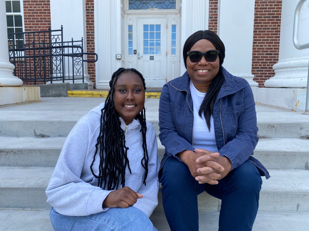 Nyaruot and Tanya Smith sitting on stairs on the UNO campus. 