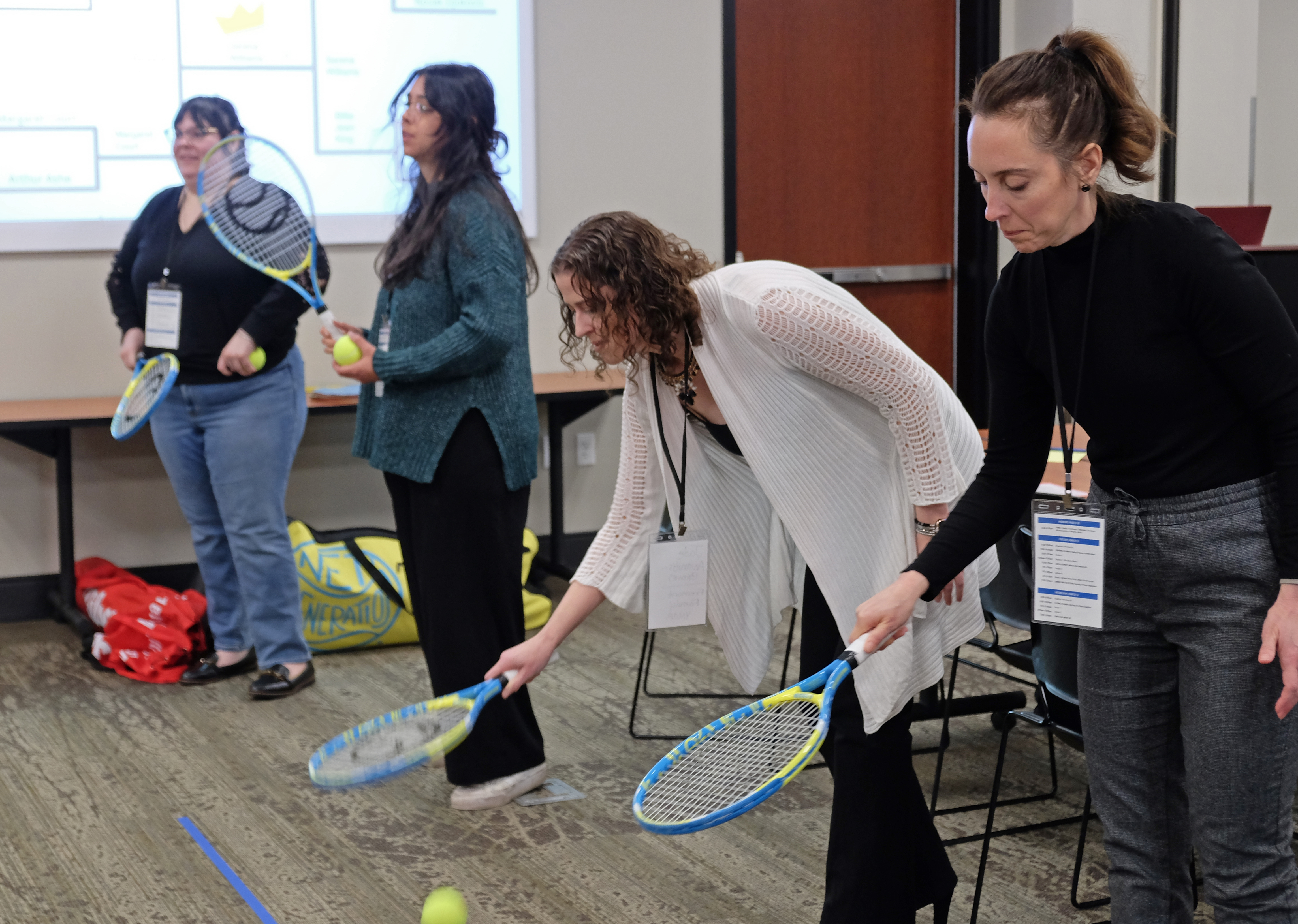 Conference attendees participating in a tennis activity.