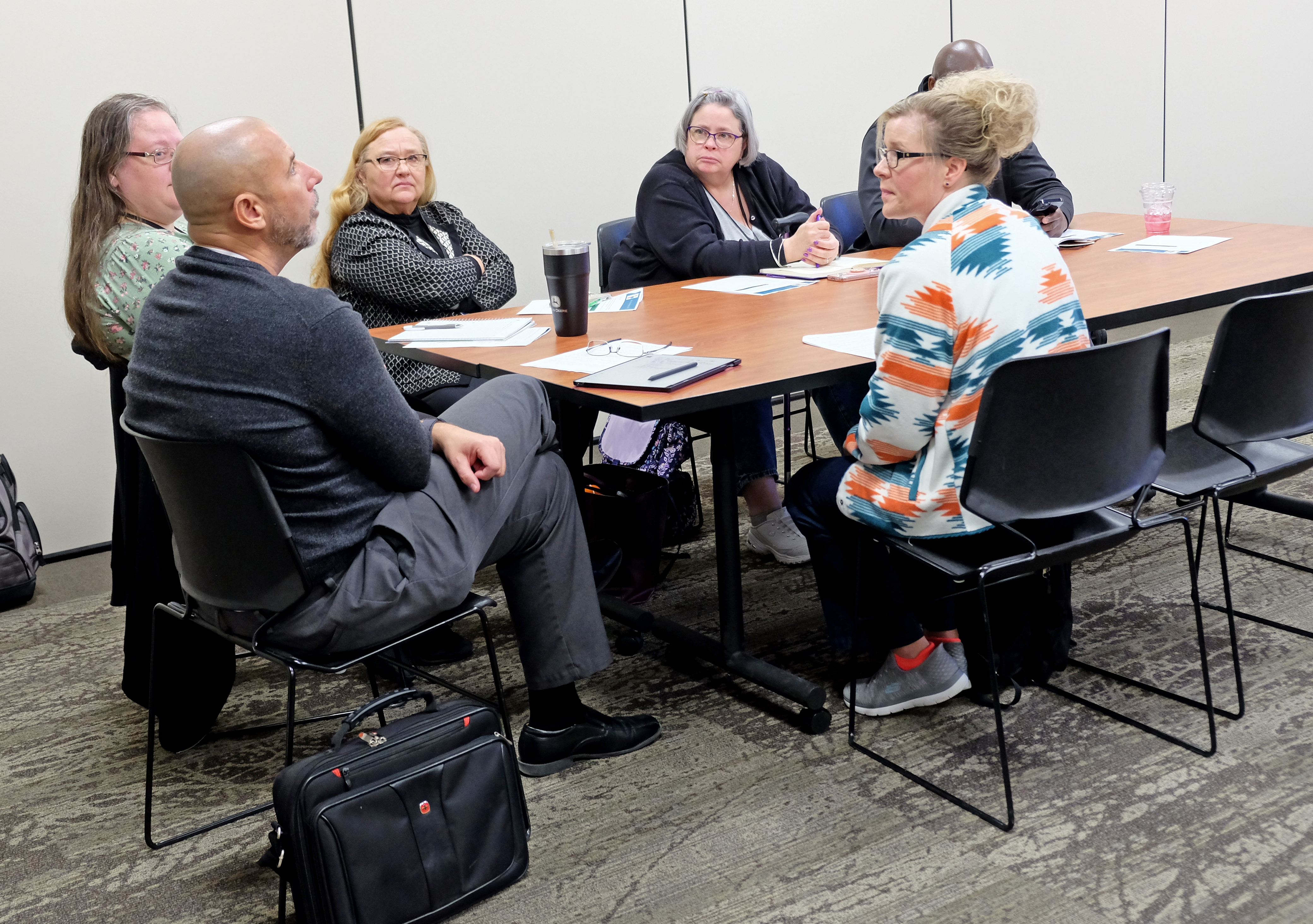 Conference attendees gathered around a table sharing ideas.