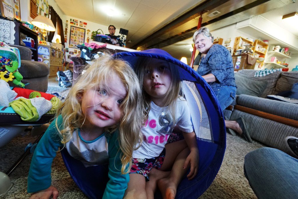 young kids playing at childcare with providers looking on